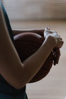A basketball player holding a ball with a blurred background, in a vertical shot.