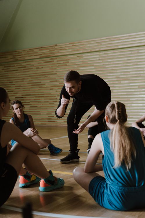 Trener u dvorani vodi trening mlade košarkaške ekipe