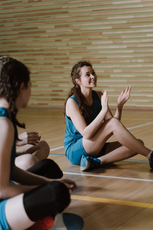 A Woman in Blue Sportswear Sitting on the Wooden Floor · Free Stock Photo