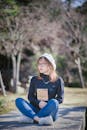 A Pretty Woman Sitting while Holding a Book