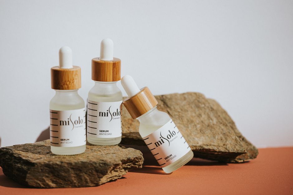 Elegant natural cosmetic serums presented on rustic stones with a minimalist design.