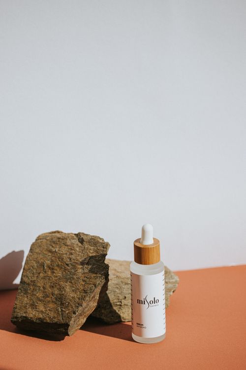 Free Elegant skincare product in a minimalist setup with natural stones on a white background. Stock Photo