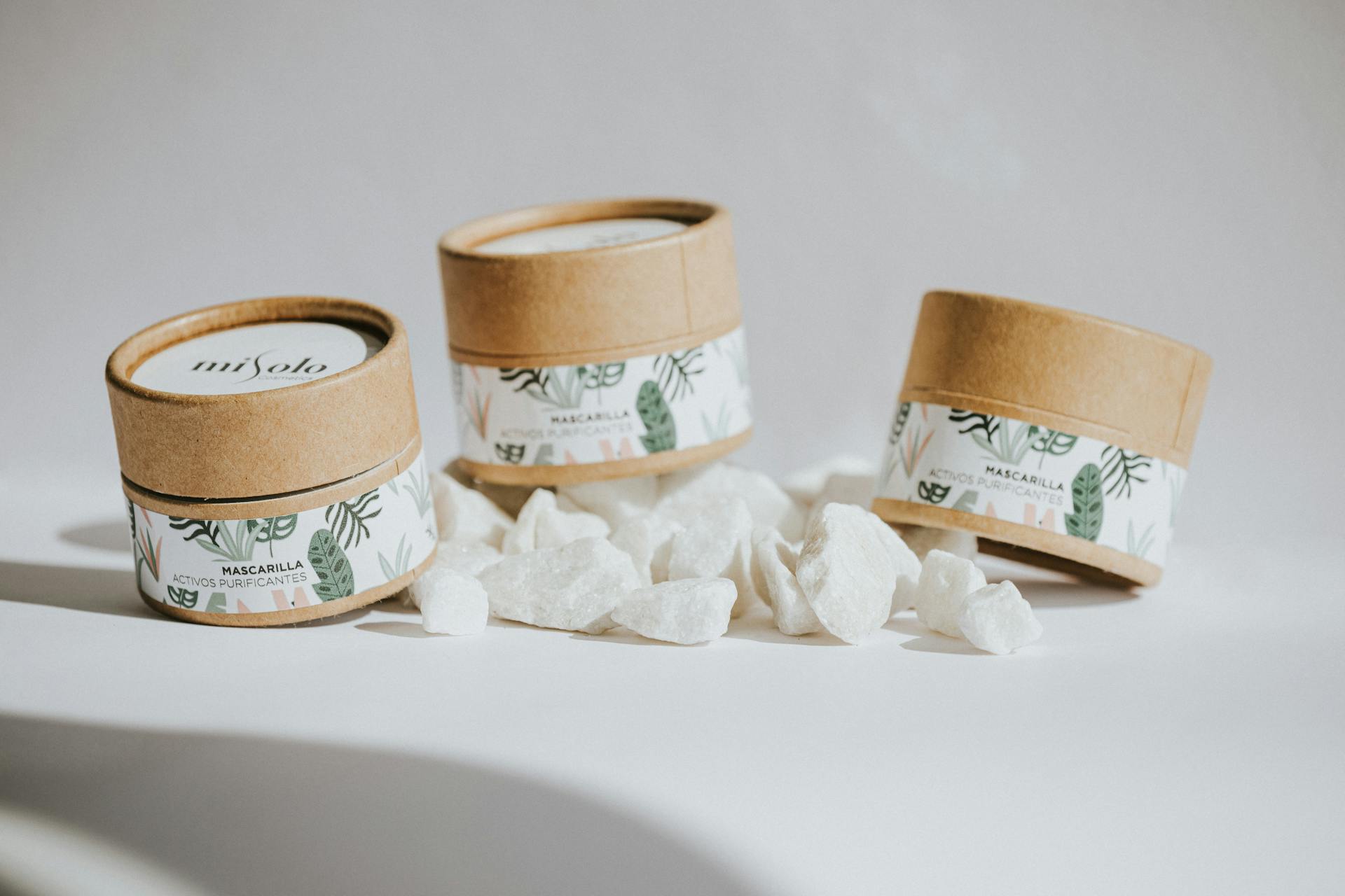 Minimalist still life of eco-friendly skincare product packaging with natural stones.