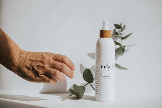 A soothing toner displayed with green leaves on a white surface, showcasing natural beauty.