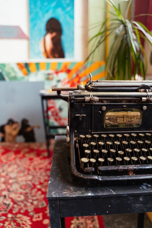 Free A classic vintage typewriter sits on a table with colorful artistic background. Stock Photo