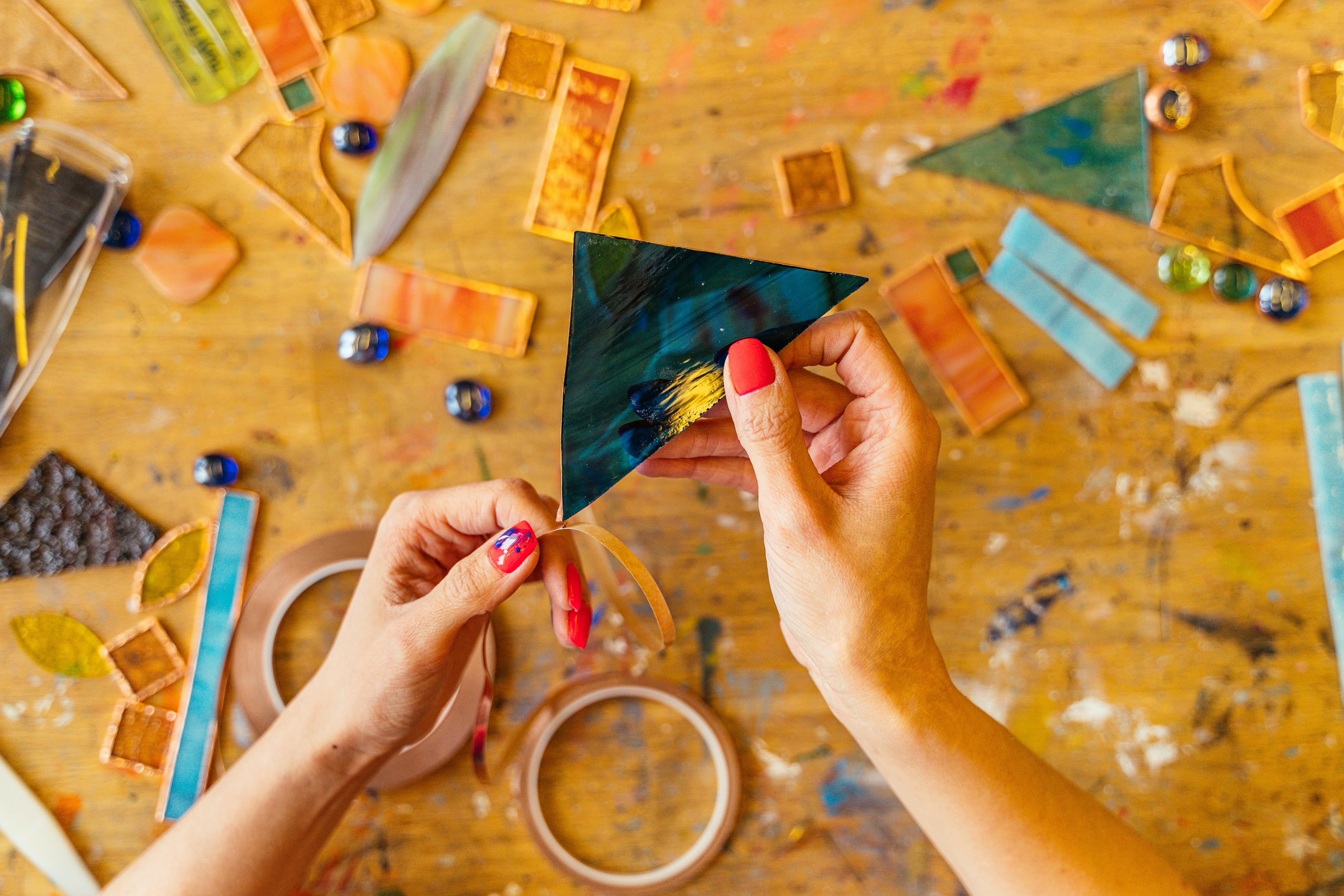 woman holding a cut piece of colorful glass