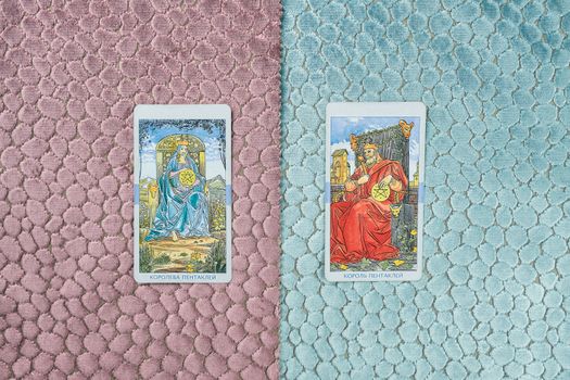 Two tarot cards featuring a king and queen on vivid textured fabrics, ideal for mysticism themes.