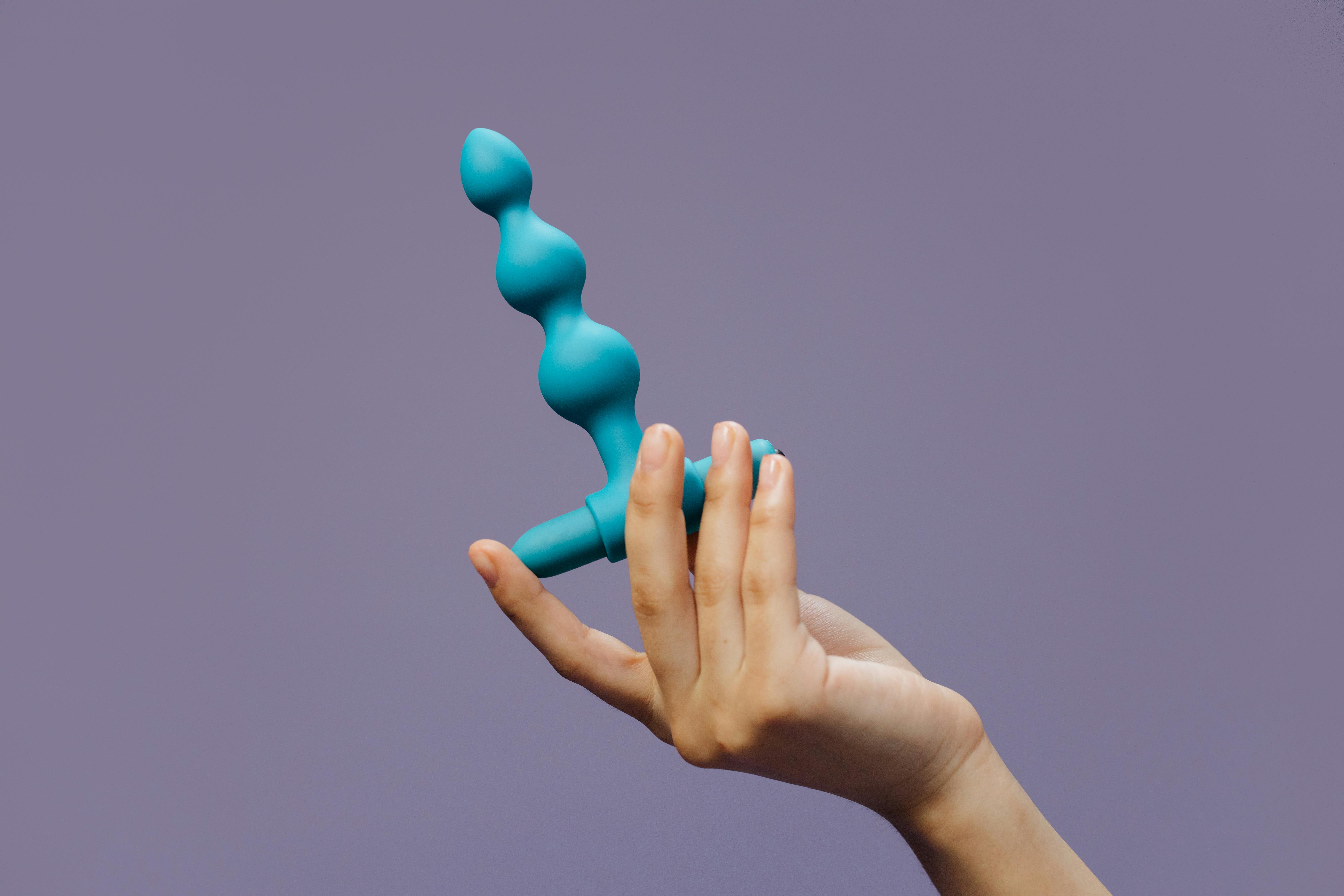 a person holding a sex toy