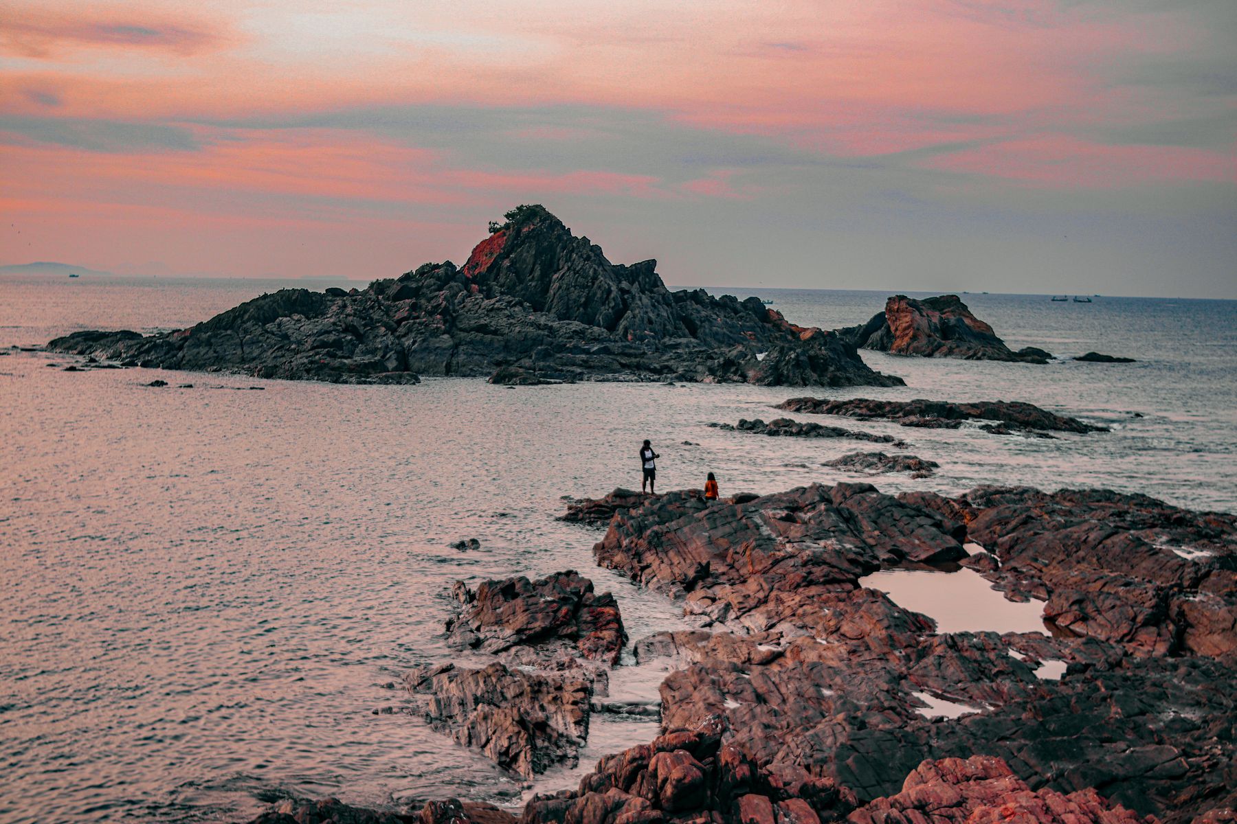 A crescent beach below red laterite cliffs on the Karnataka coast