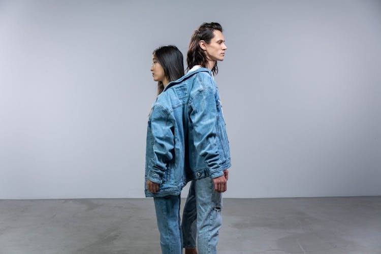 A Man And Woman In Denim Jackets And Pants