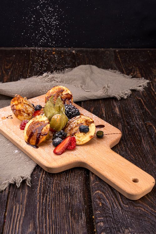 Free Delicious pastries with berries on a wooden board, perfect for a mouthwatering treat. Stock Photo