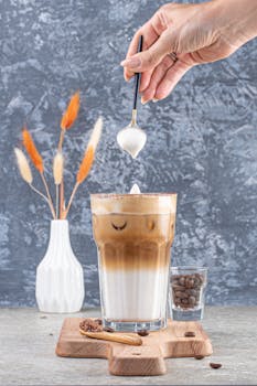 A refreshing iced latte with frothy cream, perfect for coffee lovers. Shot indoors.