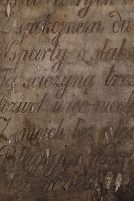 Close-up of an old marble surface with elegant script writing, suggesting historical significance.