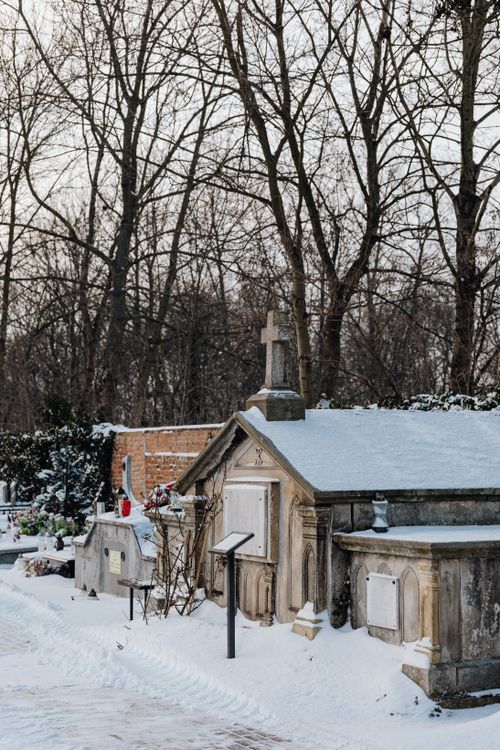 Free Peaceful cemetery in winter with snow-covered tombs and bare trees. Stock Photo