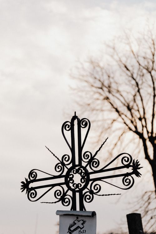 Free Silhouette of an intricate cross with a leafless tree in the background, conveying a moody atmosphere. Stock Photo