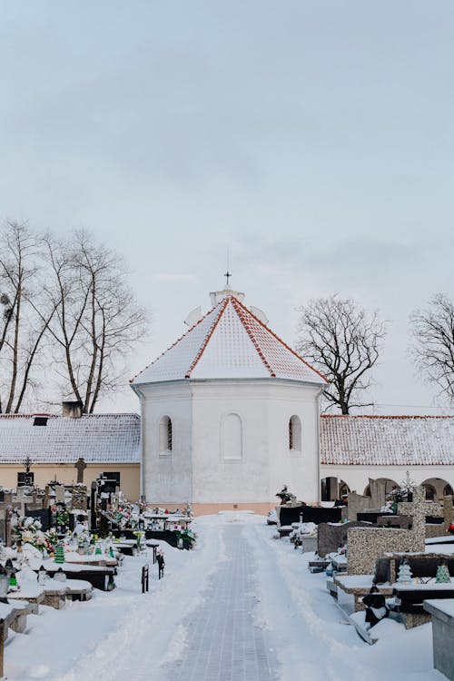 Snow Covered Pathway Leading to the Chapel in a Cemetery