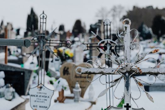 A serene winter scene of an historic cemetery with snow-covered crosses and tombstones.