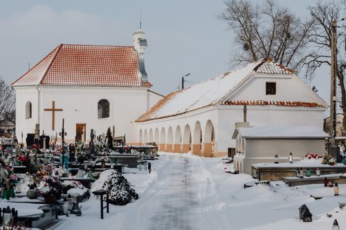 Free Winter scene of a cemetery with a snow-covered chapel and graves, showcasing serenity and solitude. Stock Photo