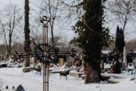 Metal Crucifix in a Snowy Cemetery