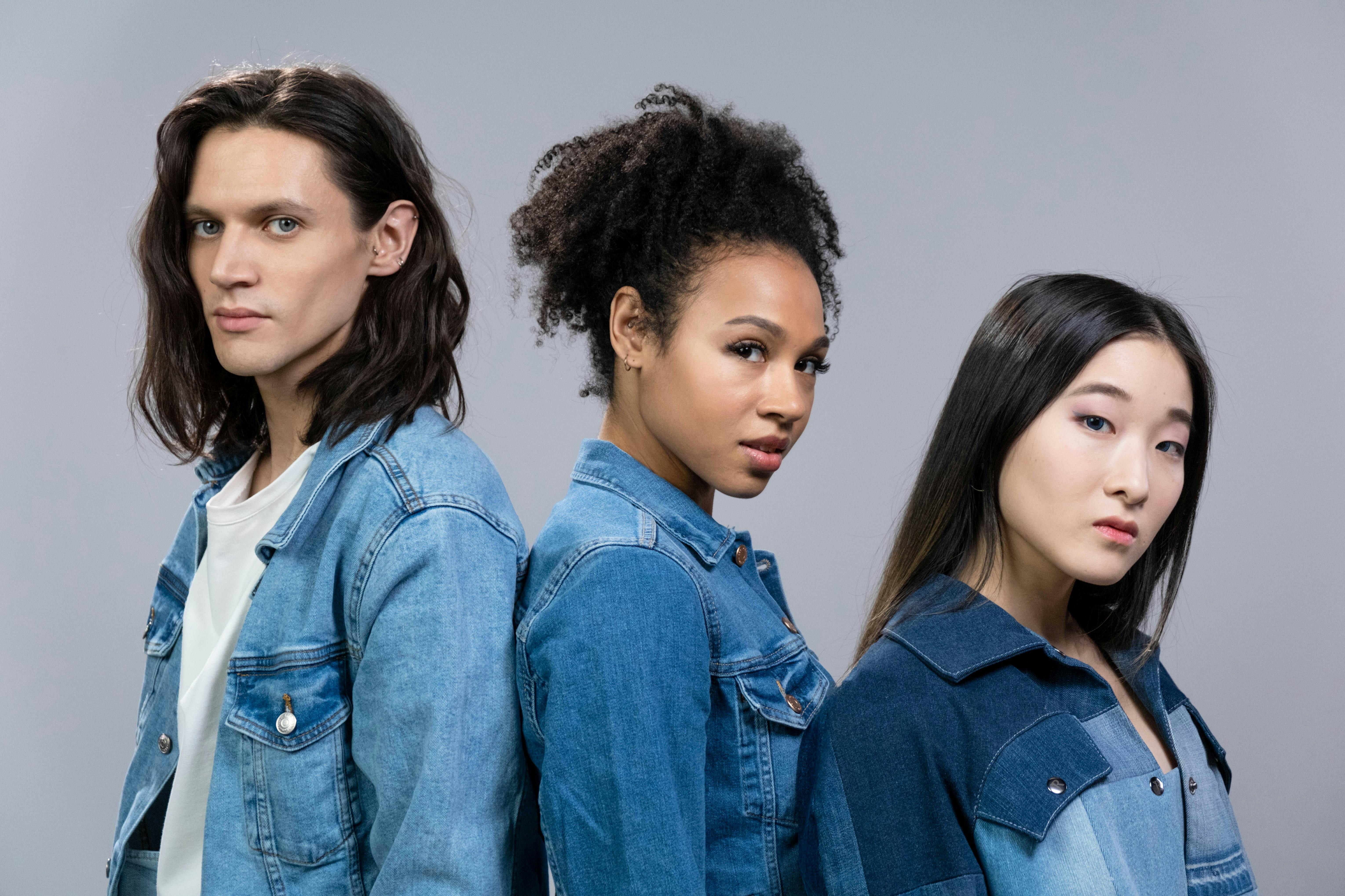 man and two women in denim jackets posing