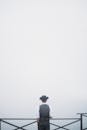 Back View of a Man Standing by the Railings during Foggy Weather