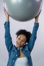 Woman in Blue Denim Jacket Holding White Ball