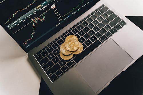 Gold Bitcoins on Laptop with Graph on Screen