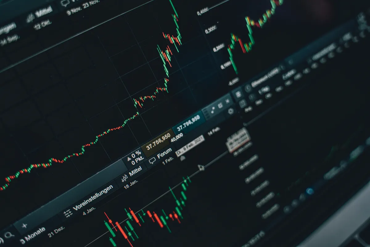 Multiple financial graphs and candlestick charts displayed across a laptop screen