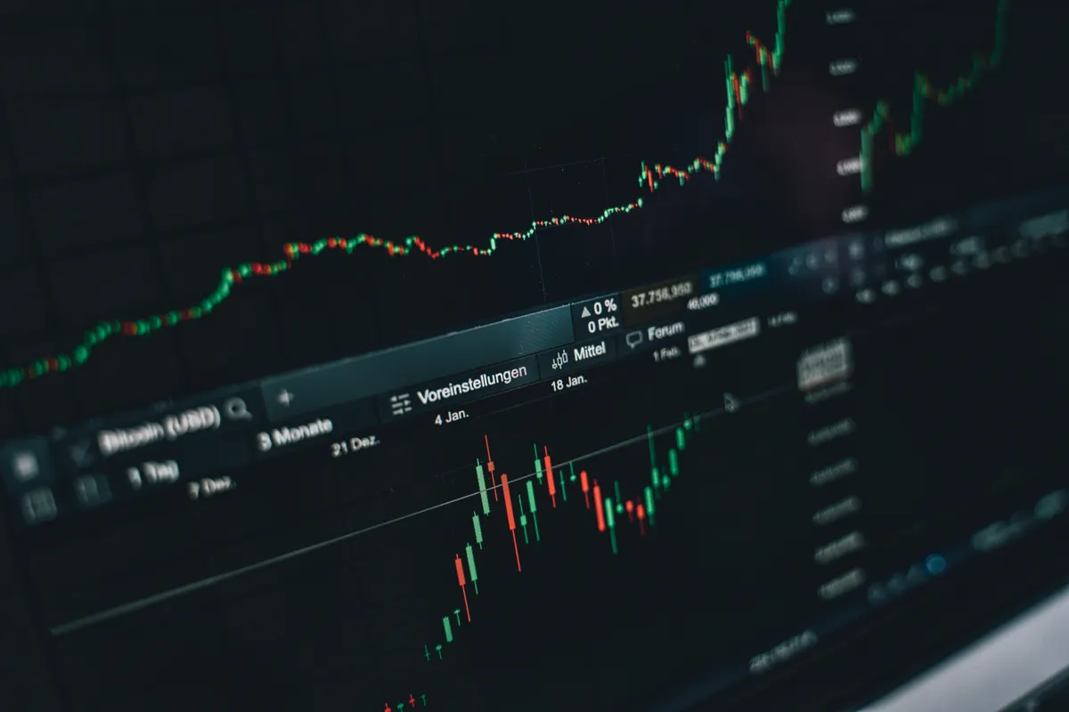 A dark monitor displaying a candlestick chart with a price ladder and open order panel.