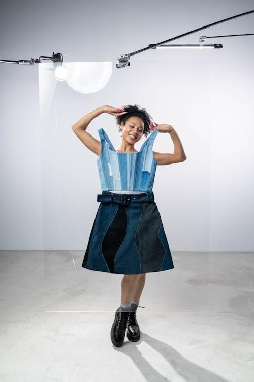 A Woman Standing Behind a Glass Board with Denim Dress