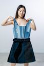 Woman in Blue Sleeveless Top and Black Denim Skirt