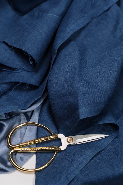 Free Top view of elegant golden scissors placed on rich blue denim fabric, showcasing texture and color contrast. Stock Photo