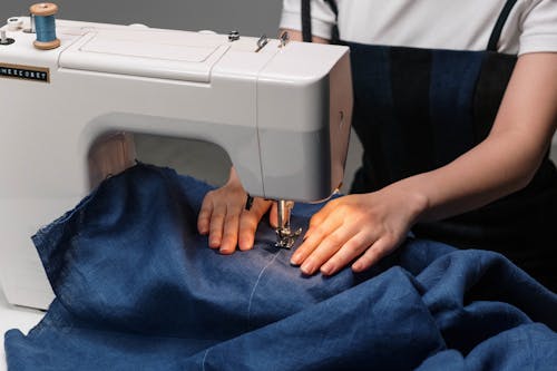 Hands of a Woman Sewing Fabric Using an Electric Sewing Machine