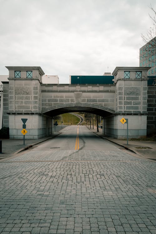 Symmetrical View of a Brick Bridge Over a Cobblestone Street 