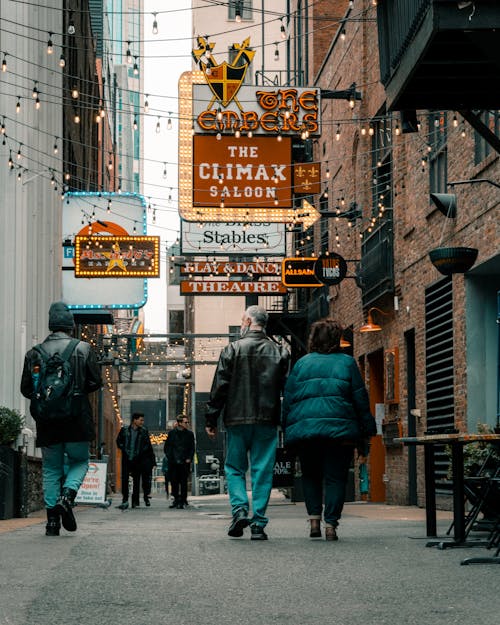 People Walking on an Alley with Signages on Buildings