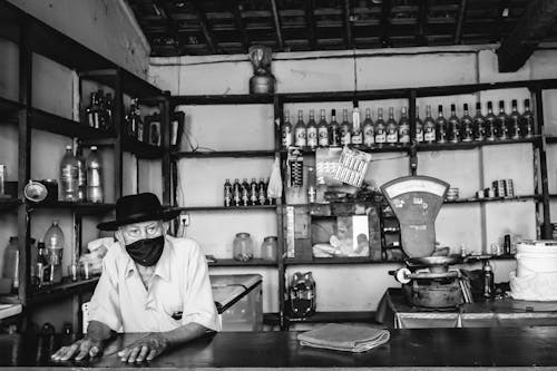 Grayscale Photo pf a Man Wearing Black Hat and Black Face Mask