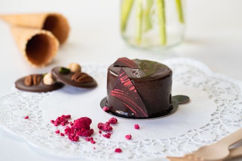 Free Indulge in a close-up of a gourmet chocolate cake with decorative berries and nuts. Stock Photo