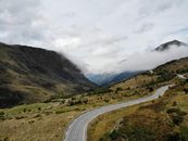 Scenic landscape of road in mountainous valley against misty sky