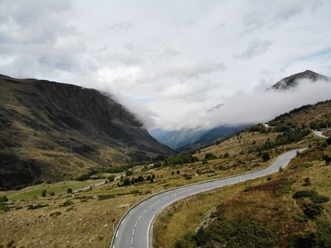 Scenic landscape of road in mountainous valley against misty sky
