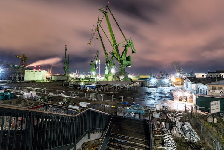 Cargo Ships With Cranes In Port At Sunset