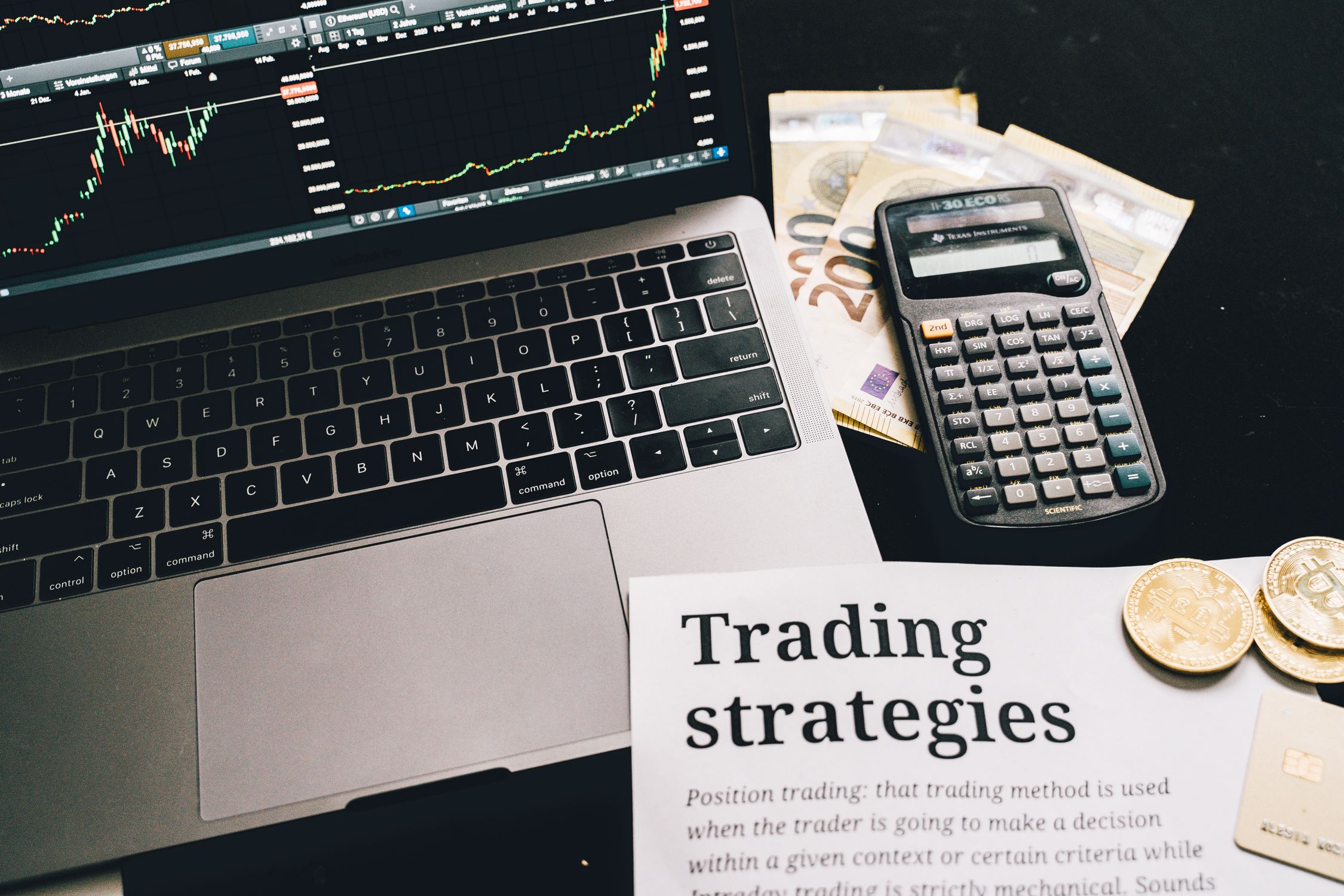 Person working with financial calculator and trading data on desk