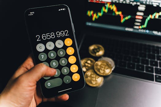A smartphone displays a calculator app beside bitcoins and a laptop with a financial chart.