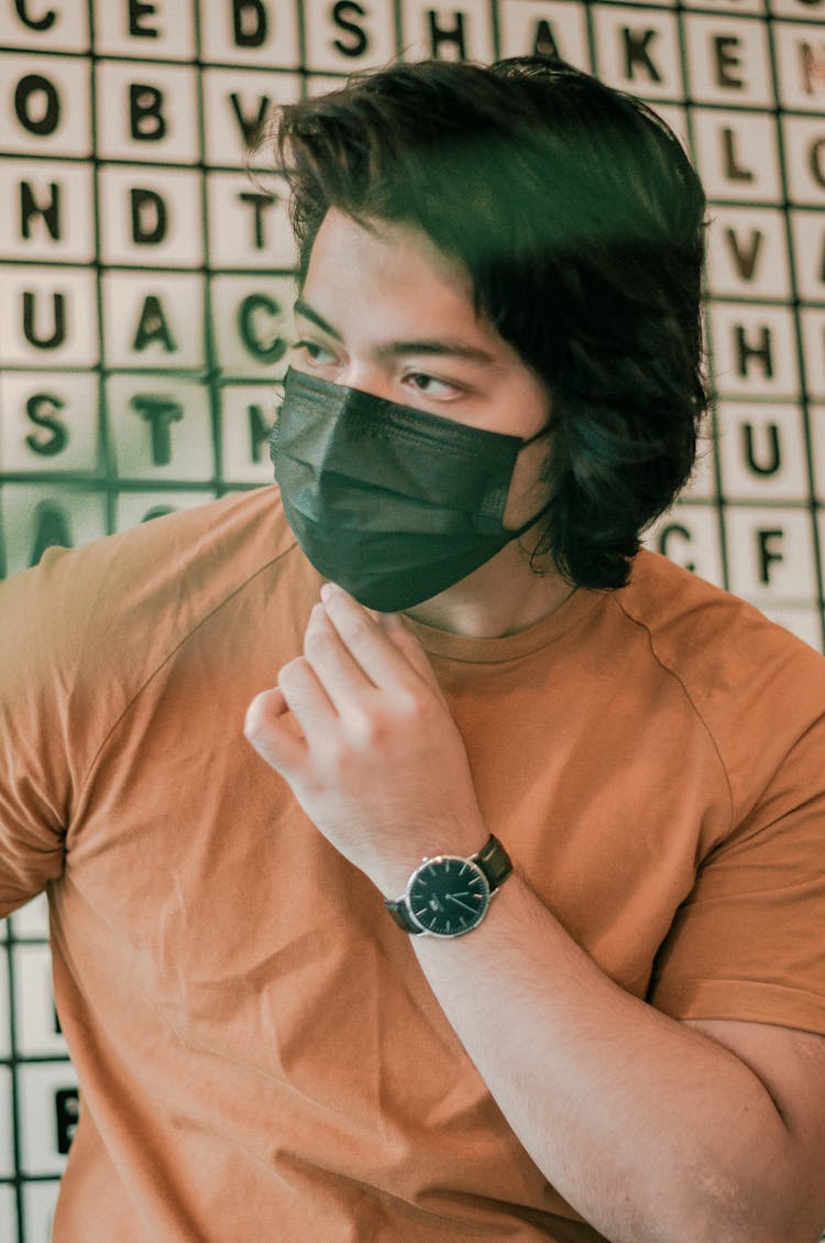 Serious Asian Man In Medical Mask Sitting In Cafeteria