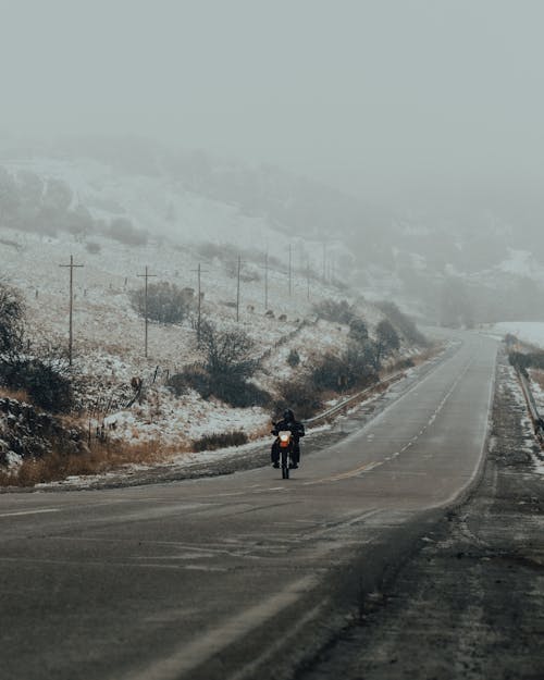 A Person Riding a Motorbike on a Foggy Road