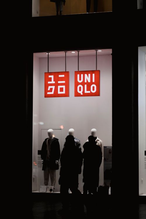 Free Nighttime view of a Uniqlo store display with mannequins in urban setting. Stock Photo