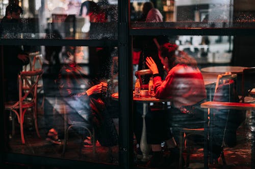 Picture Taken From Behind the Window of People Sitting in a Bar 