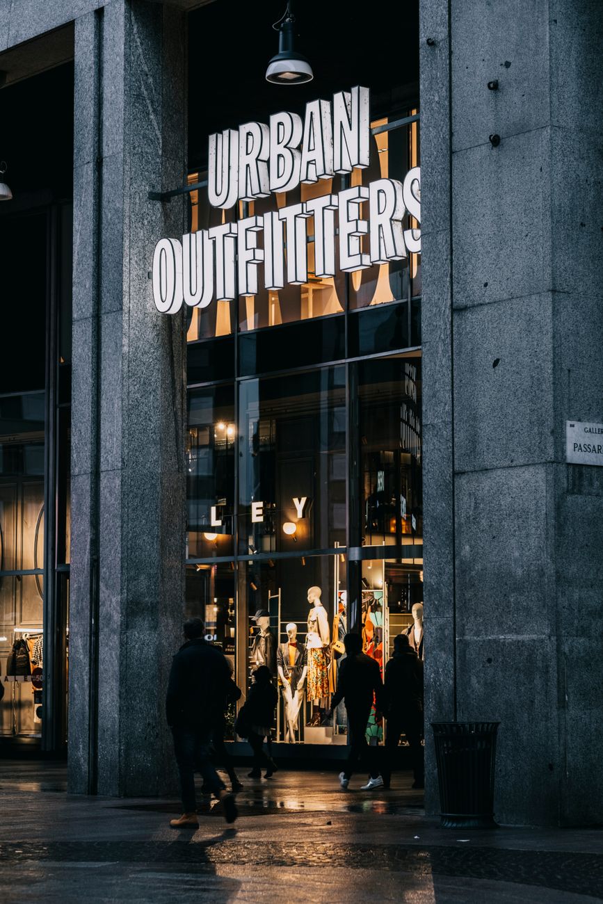 View of Urban Outfitters entrance with shoppers on a bustling city street