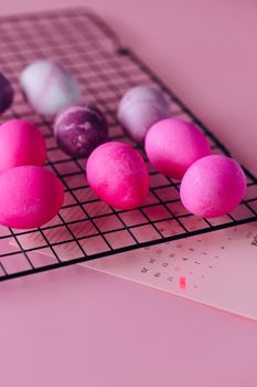 Brightly colored Easter eggs drying on a wire rack, highlighting festive creativity.