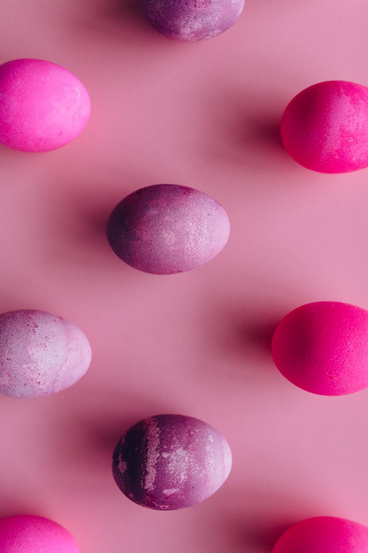 Pink And Purple Painted Chicken Eggs On Pink Surface