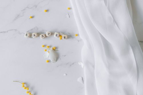 Free Minimalist Easter theme with delicate decor and text on marble background. Stock Photo